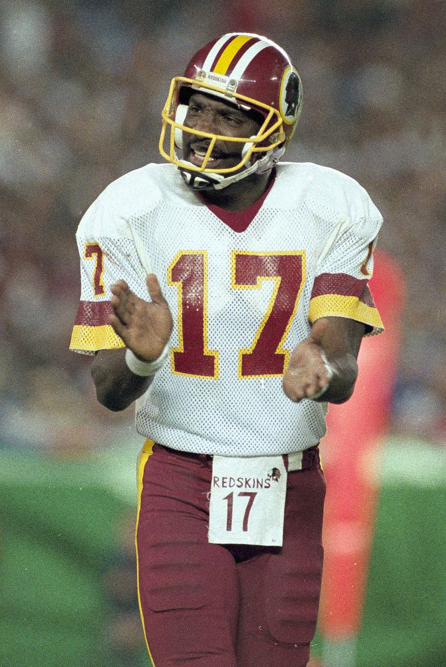 ** FILE ** Washington Redskins quarterback Doug Williams, most valuable player of Super Bowl XXII, cheers his team on during third quarter of game with Denver Broncos in San Diego, Ca., in this Jan. 31, 1988 file photo. When Doug Williams became the first black quarterback to start a Super Bowl 19 years ago, he was the object of what is considered No. 1 on the list of all-time wacky Super Bowl questions: "How long have you been a black quarterback?" Race again will be the focus next week, when Tony Dungy and Lovie Smith become the first two black coaches in the game. (AP Photo/Amy Sancetta)
