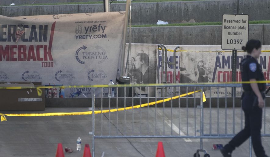 A police officer walks near the scene of the shooting of Charlie Kirk at Utah Valley University in Orem, Utah, Thursday, Sept. 11, 2025. (AP Photo/Lindsey Wasson)