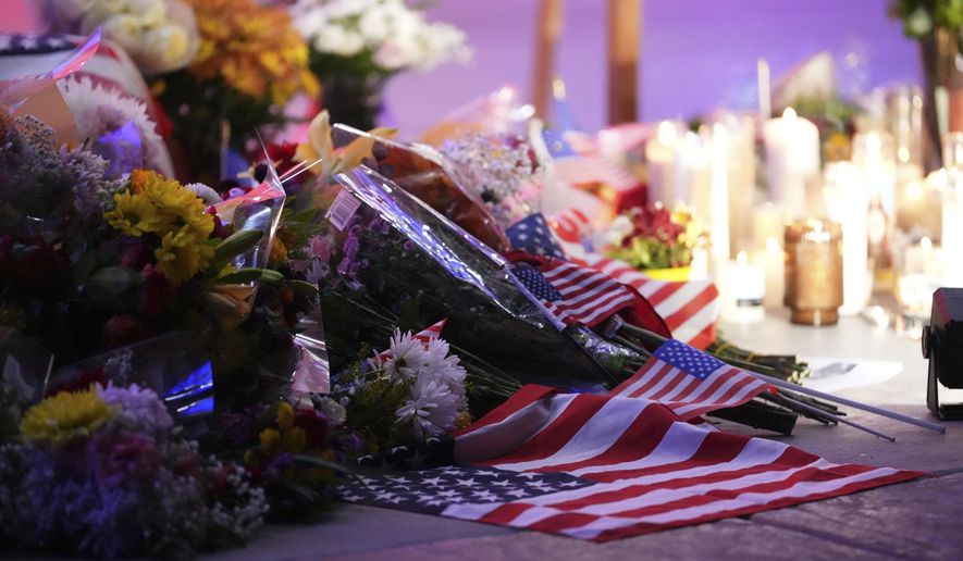 Flowers, candles and American flags sit at a vigil for Charlie Kirk, the CEO and co-founder of Turning Point USA who was shot and killed, Thursday, Sept. 11, 2025, in Orem, Utah. (AP Photo/Lindsey Wasson)