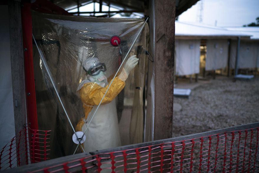 FILE - A health worker wearing protective suit enters an isolation pod to treat a patient at a treatment center in Beni, Democratic Republic of Congo, Saturday, July 13, 2019. (AP Photo/Jerome Delay, File)