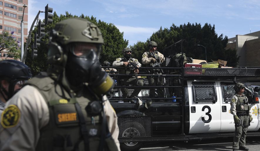 Law enforcement officers stand guard during a protest in Los Angeles on June 14, 2025. (AP Photo/Ethan Swope) **FILE**