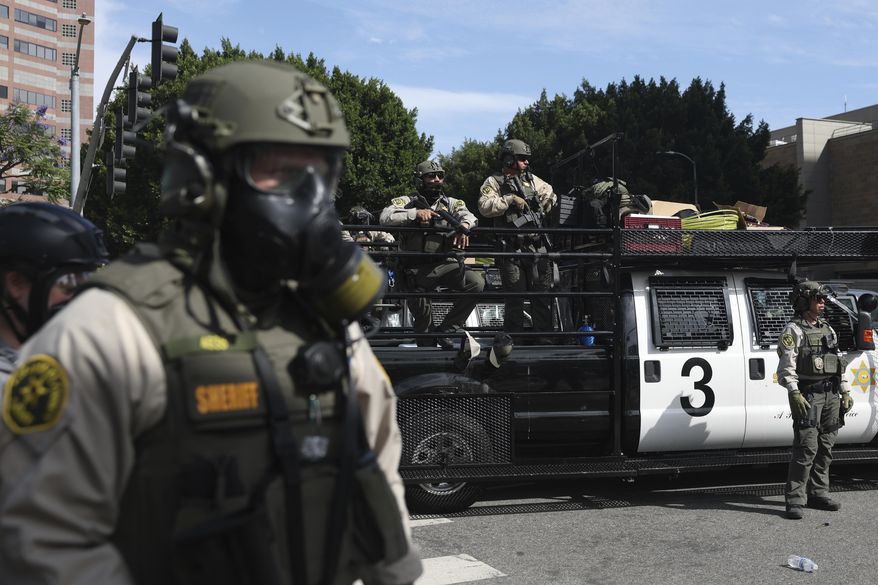 Law enforcement officers stand guard during a protest in Los Angeles on June 14, 2025. (AP Photo/Ethan Swope) **FILE**