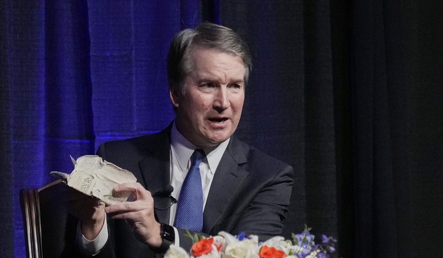 Justice Brett Kavanaugh holds his personal pocket Constitution as he speaks at The Ken Starr Lecture at McLennan Community College, Thursday, Sept. 11, 2025, in Waco, Texas. (AP Photo/Tony Gutierrez)