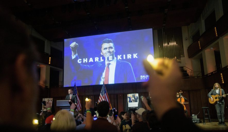 People hold candles and sing during a memorial and prayer vigil for Charlie Kirk at the John F. Kennedy Memorial Center for the Performing Arts, Sunday, Sept. 14, 2025, in Washington. (AP Photo/Rod Lamkey, Jr.)