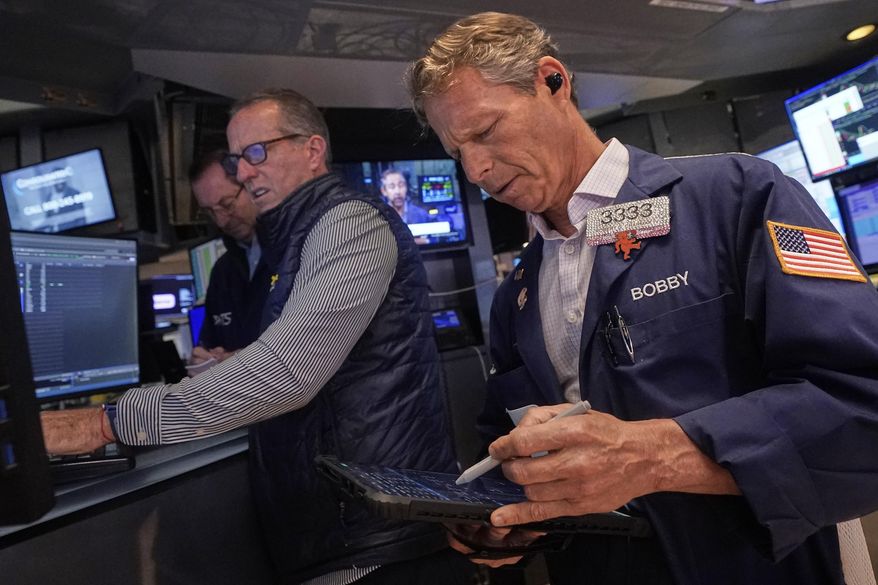 Trader Robert Charmak, right, and specialist Glenn Carell, center, work on the floor of the New York Stock Exchange, Wednesday, Sept. 10, 2025. (AP Photo/Richard Drew)