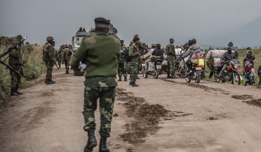 FILE - People walk on the road near Kibumba, north of Goma, Democratic Republic of Congo, as they flee fighting between Congolese forces and M23 rebels in North Kivu, May 24, 2022. (AP Photo/Moses Sawasawa, file)