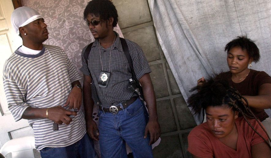 FILE - Wilfort Ferdinand, second left, talks with a member of his security team in Gonaives, March 6, 2004. (AP Photo/Walter Astrada, File)