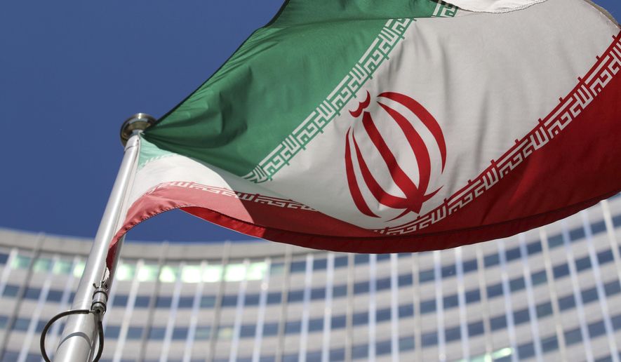 FILE - The Iranian flag flies in front of a U.N. building where closed-door nuclear talks take place at the International Center in Vienna, Austria, on June 18, 2014. (AP Photo/Ronald Zak, File)