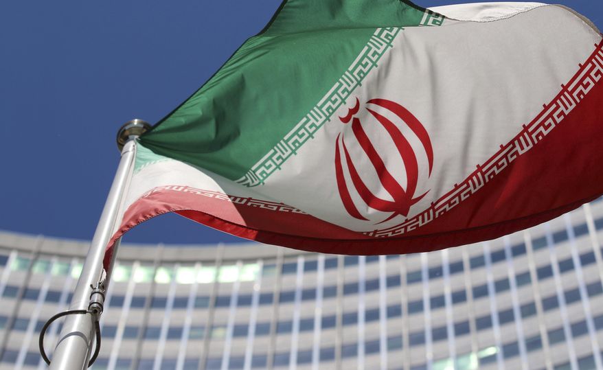 FILE - The Iranian flag flies in front of a U.N. building where closed-door nuclear talks take place at the International Center in Vienna, Austria, on June 18, 2014. (AP Photo/Ronald Zak, File)