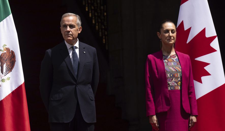Canada's Prime Minister Mark Carney and Mexican President Claudia Sheinbaum stand on the podium during an official welcome ceremony at the National Palace in Mexico City, Thursday, Sept. 18, 2025. (Adrian Wyld/The Canadian Press via AP)