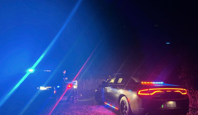 In this photo provided by the Thurston County Sheriff's Office, law enforcement personnel respond to a Wednesday evening, Sept. 17, 2025, helicopter crash near Joint Base Lewis-McChord in Washington state. (Thurston County Sheriff's Office via AP)
