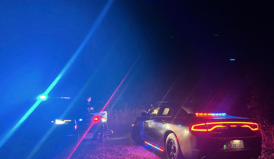 In this photo provided by the Thurston County Sheriff's Office, law enforcement personnel respond to a Wednesday evening, Sept. 17, 2025, helicopter crash near Joint Base Lewis-McChord in Washington state. (Thurston County Sheriff's Office via AP)