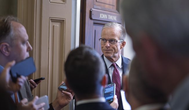 Senate Majority Leader John Thune, R-S.D., is met by reporters as he walks to his office while Congress works on a government funding solution, at the Capitol in Washington, Thursday, Sept. 18, 2025. (AP Photo/J. Scott Applewhite)
