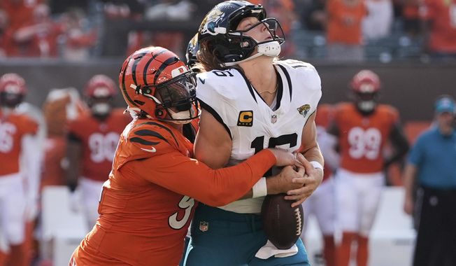 Jacksonville Jaguars quarterback Trevor Lawrence (16) is sacked by Cincinnati Bengals defensive end Trey Hendrickson during the second half of an NFL football game, Sunday, Sept. 14, 2025, in Cincinnati. (AP Photo/Carolyn Kaster)