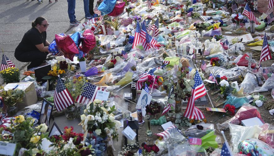 A well-wisher pauses at a growing makeshift memorial set up at the Turning Point USA headquarters after the shooting death at a Utah college last Wednesday of Charlie Kirk, the 31-year-old founder and CEO of the organization, Wednesday, Sept. 17, 2025, in Phoenix. (AP Photo/Ross D. Franklin)