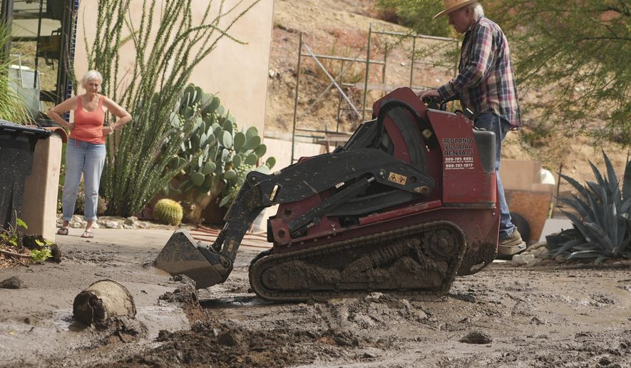 Residents clean up the damage caused by mudslides after storms in Yucaipa, Calif., Friday, Sept. 19, 2025. (AP Photo/Damian Dovarganes)