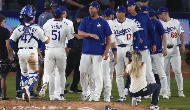 Los Angeles Dodgers' Clayton Kershaw, center, congratulates members of his team after the Dodgers defeated the San Francisco Giants in a baseball game Thursday, Sept. 18, 2025, in Los Angeles. (AP Photo/Mark J. Terrill)