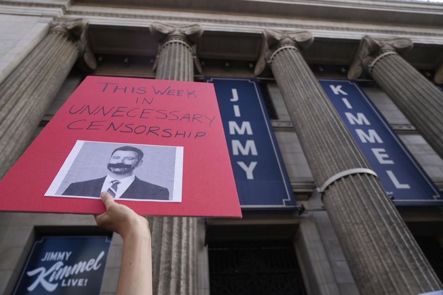 A demonstrator holds a sign outside El Capitan Entertainment Centre, where the late-night show "Jimmy Kimmel Live!" is staged on Thursday, Sept. 18, 2025, in Los Angeles. (AP Photo/Damian Dovarganes)