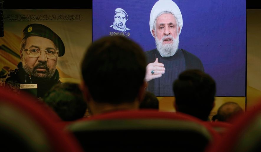 FILE - People listen in Dahiyeh, a southern suburb of Beirut, Lebanon, as Hezbollah leader Naim Kassem delivers a televised speech Wednesday, July 30, 2025, during a commemoration marking the first anniversary of the death of top Hezbollah commander Fouad Shukur, who was killed in an Israeli airstrike. (AP Photo/Bilal Hussei, File)