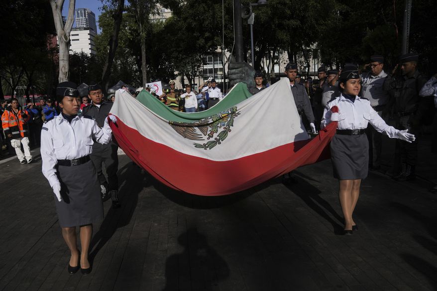 Military school cadets carry a Mexican flag during a ceremony marking the 1985 earthquake's 40th anniversary in Mexico City, Friday, Sept. 19, 2025. (AP Photo/Marco Ugarte)