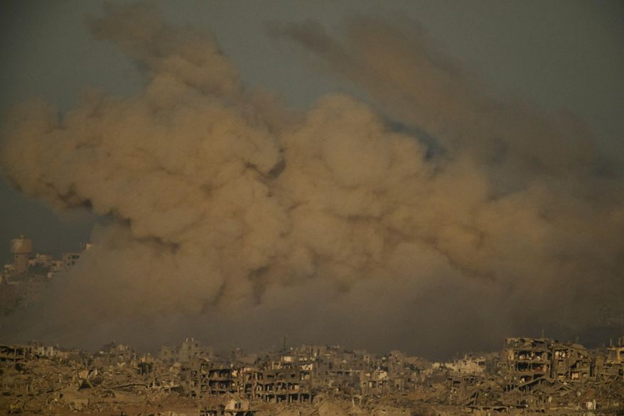 Buildings that were destroyed during the Israeli ground and air operations are engulfed by smoke following an Israeli military strike in the northern Gaza Strip, as seen from southern Israel, Saturday, Sept. 20, 2025. (AP Photo/Leo Correa)