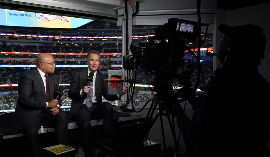 NBC Sports play-by-play announcer Mike Tirico, left, sits next to color commentator Cris Collinsworth before an NFL football game between the Los Angeles Chargers and the Miami Dolphins on Dec. 11, 2022, in Inglewood, Calif. (AP Photo/Jae C. Hong, File)