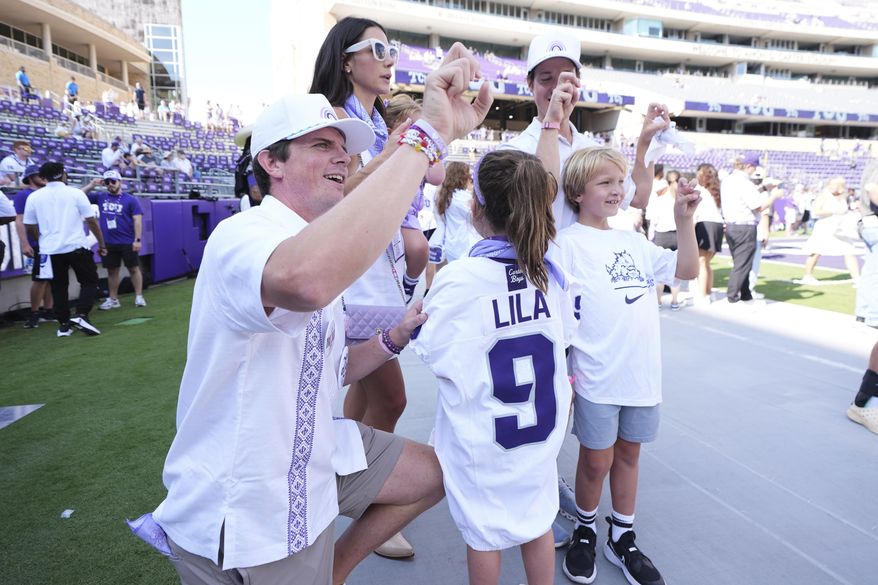 Blake Bonner, left, his wife Caitlin, left rear, standing and their daughter, front, wearing a shirt with her late sisters name stand in the end zone before an NCAA college football game between SMU and TCU, Saturday, Sept. 20, 2025, in Fort Worth, Texas. (AP Photo/Tony Gutierrez)