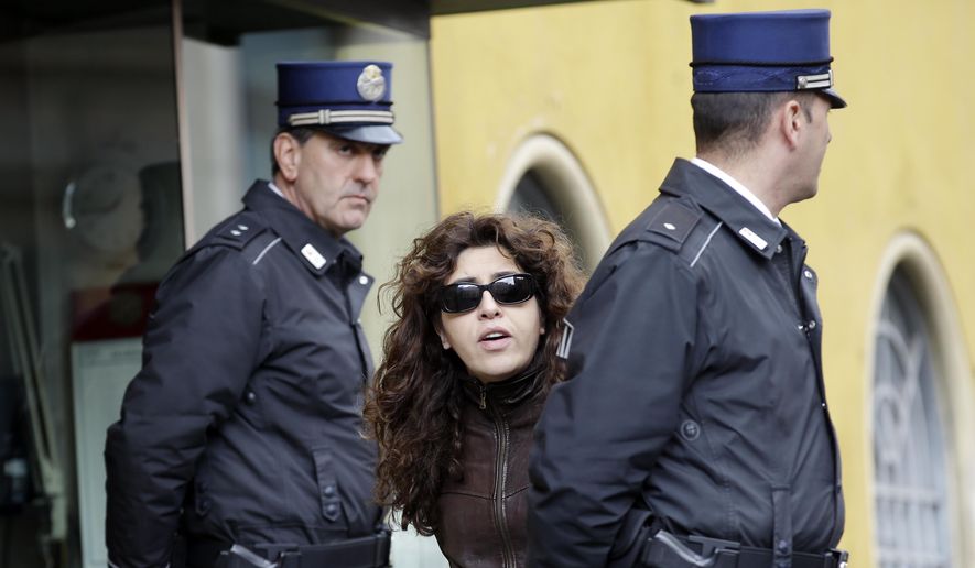 Public relations expert Francesca Chaouqui walks past two Vatican Gendarmi as she leaves the Vatican during a pause of her trial, March 15, 2016. (AP Photo/Andrew Medichini, File)