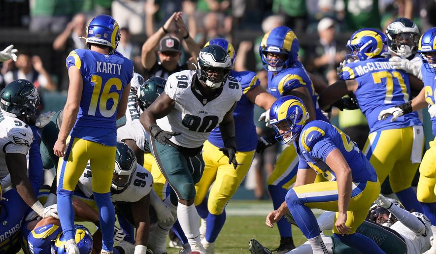 Philadelphia Eagles defensive tackle Jordan Davis (90) prepares to pick up the ball after blocking a field goal attempt by Los Angeles Rams kicker Joshua Karty (16) and run the ball back for a touchdown as time expires during the second half of an NFL football game against the Los Angeles Rams Sunday, Sept. 21, 2025, in Philadelphia. (AP Photo/Chris Szagola)