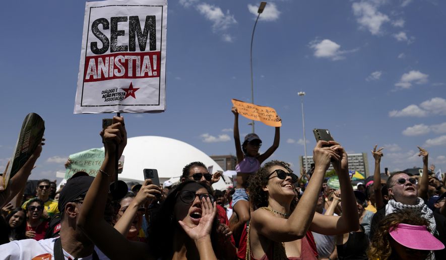 Activists chant "No amnesty" during a protest against an amnesty bill that could absolve former President Jair Bolsonaro and his allies convicted for a 2023 coup attempt, in Brasilia, Brazil, Sunday, Sept. 21, 2025. (AP Photo/Eraldo Peres)