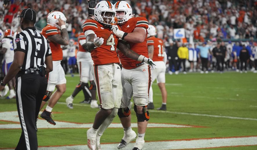 Miami running back Mark Fletcher Jr. (4) celebrates with offensive lineman James Brockermeyer, right, after scoring a touchdown during the second half of an NCAA college football game against Florida, Saturday, Sept. 20, 2025, in Miami Gardens, Fla. (AP Photo/Lynne Sladky)
