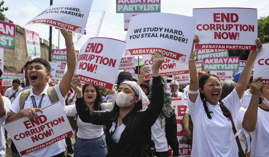 Protesters carry signs as they gather during a rally against government corruption at the EDSA People Power Monument in suburban Mandaluyong, east of Manila, Philippines, Sunday. Sept. 21, 2025. (AP Photo/Basilio Sepe)