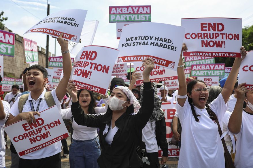 Protesters carry signs as they gather during a rally against government corruption at the EDSA People Power Monument in suburban Mandaluyong, east of Manila, Philippines, Sunday. Sept. 21, 2025. (AP Photo/Basilio Sepe)