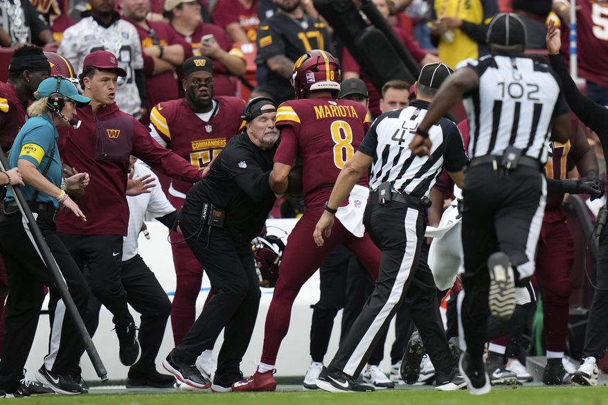 Washington Commanders Dan Quinn is run into on the sideline during the first half of NFL football game against the Las Vegas Raiders, Sunday, Sept. 21, 2025, in Landover, Md. (AP Photo/Stephanie Scarbrough)