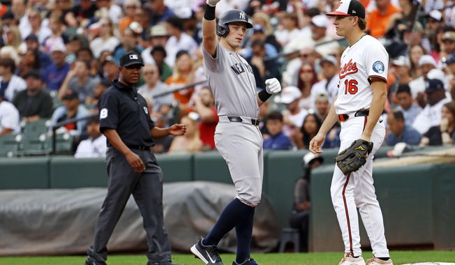 New York Yankees Ben Rice (22), center, celebrates toward his dugout after hitting a single during the second inning of a baseball against the Baltimore Orioles, Sunday, Sept. 21, 2025, in Baltimore. (AP Photo/Peter Casey)