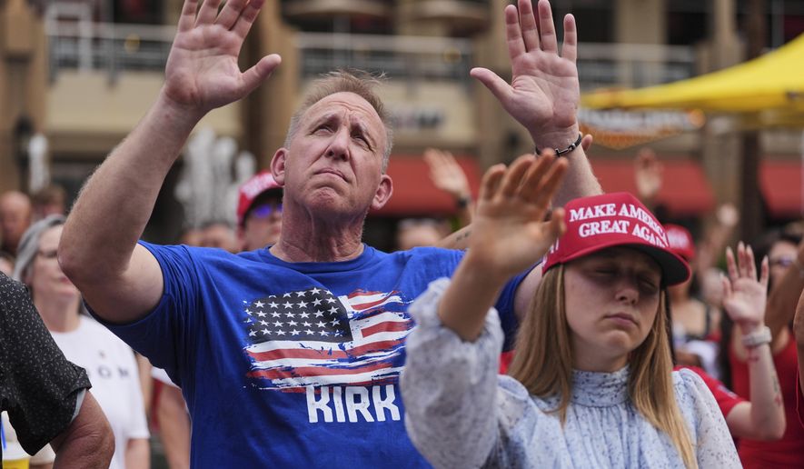 People listen to a worship song in the overflow area outside before a memorial for conservative activist Charlie Kirk, Sunday, Sept. 21, 2025, at State Farm Stadium in Glendale, Ariz. (AP Photo/Jae C. Hong)
