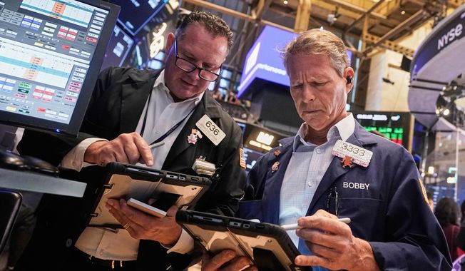 Traders Edward Curran, left, and Robert Charmak work on the floor of the New York Stock Exchange, Wednesday, Sept. 17, 2025. (AP Photo/Richard Drew)