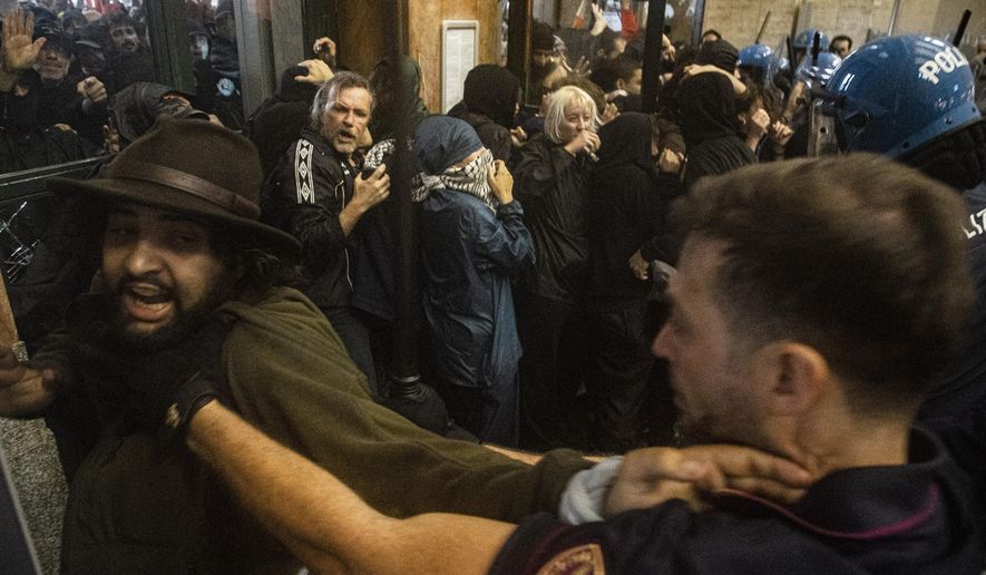 Protesters enter Central Station during clashes with police after the strike march in support of Palestine, in Milan, Italy, Monday, Sept. 22, 2025. (Marco Ottico/Lapresse via AP)
