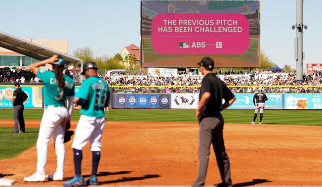 An outfield screen shows a graphic indicating Seattle Mariners' Julio Rodriguez challenged a pitch call, initiating a review with the automated ball-strike challenge system, in the third inning against the Arizona Diamondbacks during a spring training baseball game Sunday, Feb. 23, 2025, in Peoria, Ariz. (AP Photo/Lindsey Wasson, file)