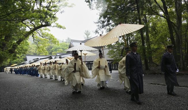 Priests and officials in the Shinto priesthood march during Yamaguchisai, a kickoff ceremony of the Shikinen Sengu ritual, which concludes in 2033, at Kotaijingu, also known as Naiku, or the inner sanctuary, of the Jingu shrine complex in Ise, central Japan, Friday, May 2, 2025. (AP Photo/Hiro Komae)