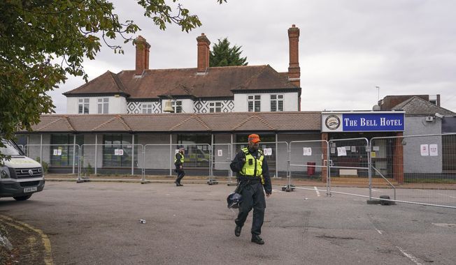 FILE - A police officer walks outside The Bell Hotel in Epping, near London, Sunday, July 27, 2025. (AP Photo/Alberto Pezzali, File)