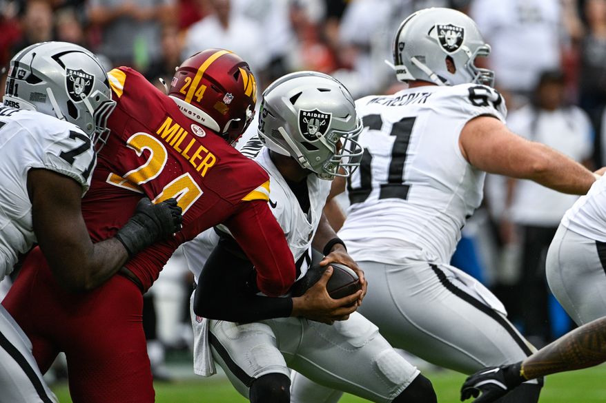 Washington Commanders linebacker Von Miller (24) brings down Las Vegas Raiders quarterback Geno Smith (7) at Northwest Stadium in Landover, Maryland, September 21, 2025. (Photo by Brian Murphy for the Washington Times)