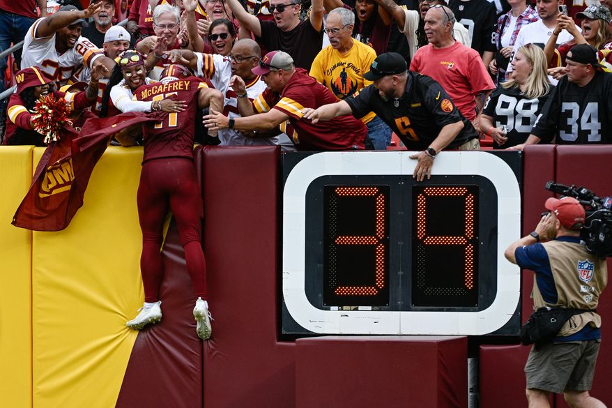 Washington Commanders receiver Luke McCaffrey (11) jumps into the stands to celebrate with fans after registering his first-career touchdown reception against the Las Vegas Raiders at Northwest Stadium in Landover, Maryland, September 21, 2025. (Photo by Brian Murphy for the Washington Times)