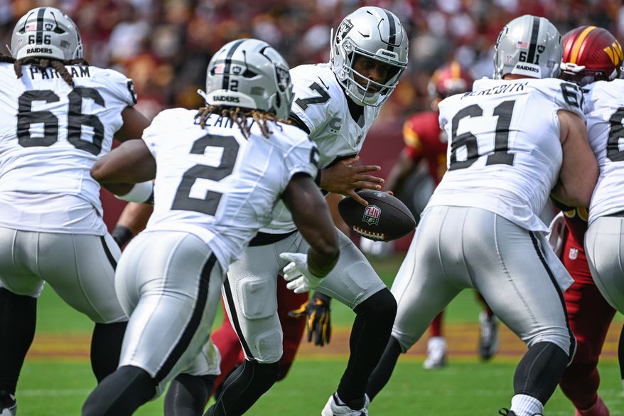 Las Vegas Raiders quarterback Geno Smith (7) hands off to rookie running back Ashton Jeanty (2) during the first quarter against the Washington Commanders at Northwest Stadium in Landover, Maryland, September 21, 2025. (Photo by Brian Murphy for the Washington Times)