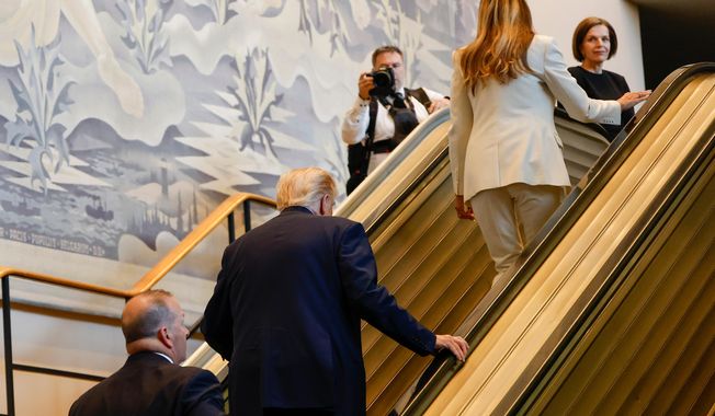 President Donald Trump, center, and First Lady Melania Trump, upper right, walk up the escalator after it stalled as he rode up to the General Assembly Hall, Tuesday, Sept. 23, 2025, at U.N. headquarters. (AP Photo/Stefan Jeremiah)