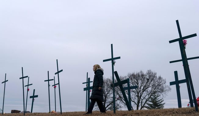 FILE - Crosses are seen at a makeshift memorial for the victims of the plane crash in the Potomac River near Ronald Reagan Washington National Airport, Friday, Jan. 31, 2025, in Arlington, Va. (AP Photo/Jose Luis Magana, file)