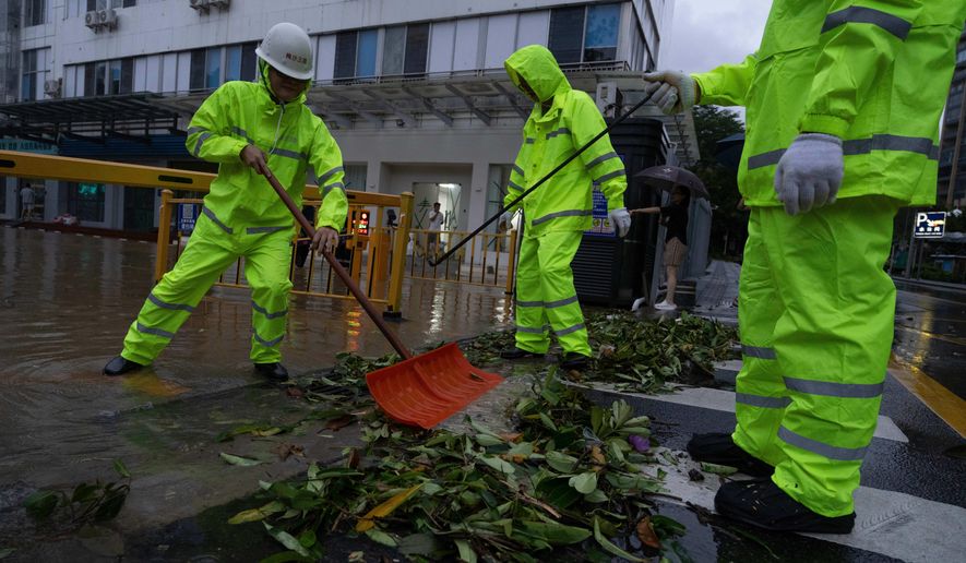 Workers clear debris clogging an entry way in the aftermath of Super Typhoon Ragasa in Shenzhen in southern China's Guangdong province on Wednesday, Sept. 24, 2025. (AP Photo/Ng Han Guan)