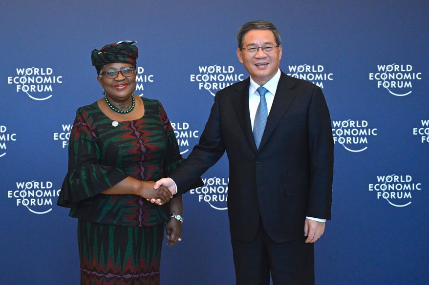 Chinese Premier Li Qiang, right, shakes hands with Director-General of the World Trade Organization Ngozi Okonjo-Iweala, in Tianjin, ahead of the annual World Economic Forum New Champions meeting Monday, June 26, 2023. (Wang Zhao/Pool Photo via AP, Filer)