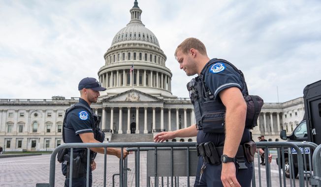 Capitol Police officers adjust security barriers around the East Plaza at the Capitol in Washington, Wednesday, Sept. 24, 2025. With just days to go before federal money runs out with the end of the fiscal year on Tuesday, Sept. 30, Congress has failed to pass legislation to keep the government running after becoming deadlocked during votes late last week. (AP Photo/J. Scott Applewhite)