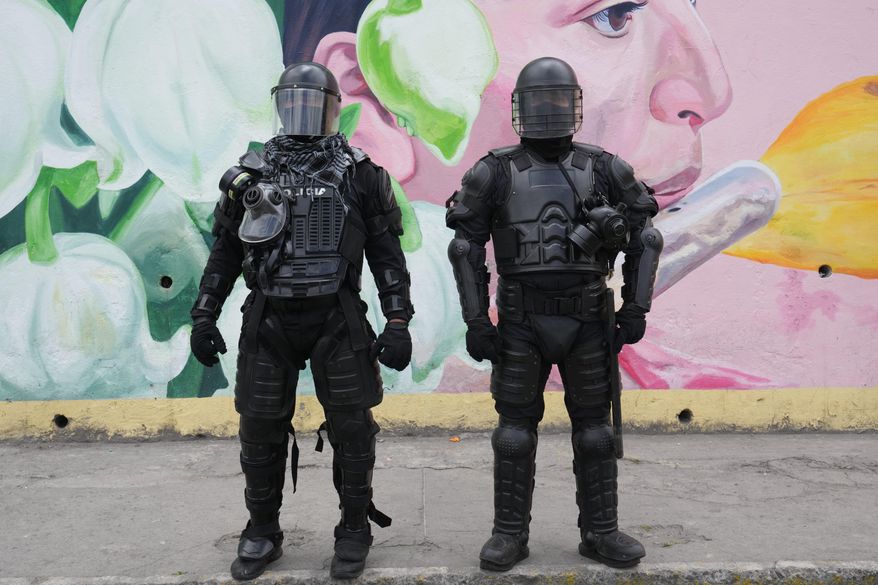 Police officers stand guard outside the Colegio Jacinto Collahuazo where President Daniel Noboa attends an event to deliver benefits and to decry the protests against diesel price hikes following his fuel subsidy cuts, in Otavalo, Ecuador, Wednesday, Sept. 24, 2025. (AP Photo/Dolores Ochoa)
